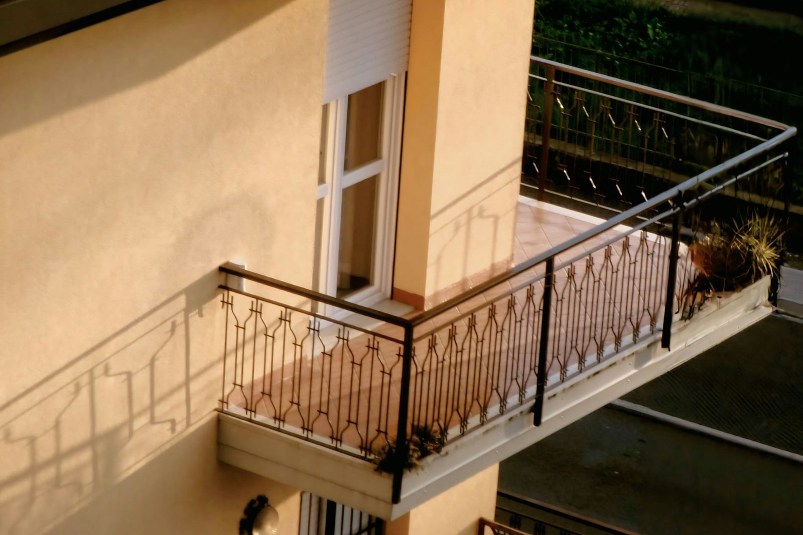 Person stellt eine Balkontür mit einem Inbusschlüssel am Scharnier ein